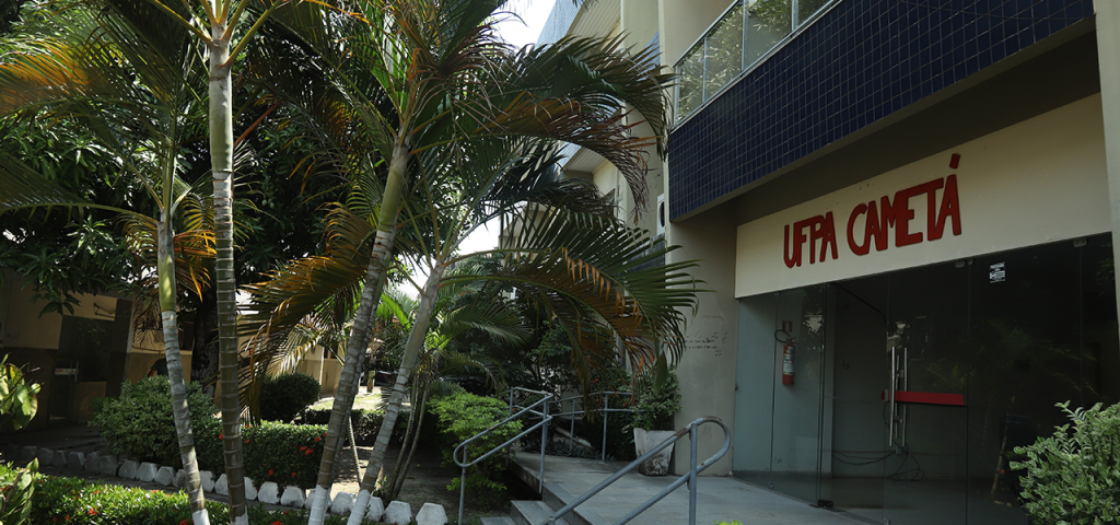 Fotografia interna do Campus Universitário de Cametá da UFPA. Aparece em destaque a fachada de um prédio com o letreiro UFPA CAMETÁ. Em frente ao prédio, há várias árvores.