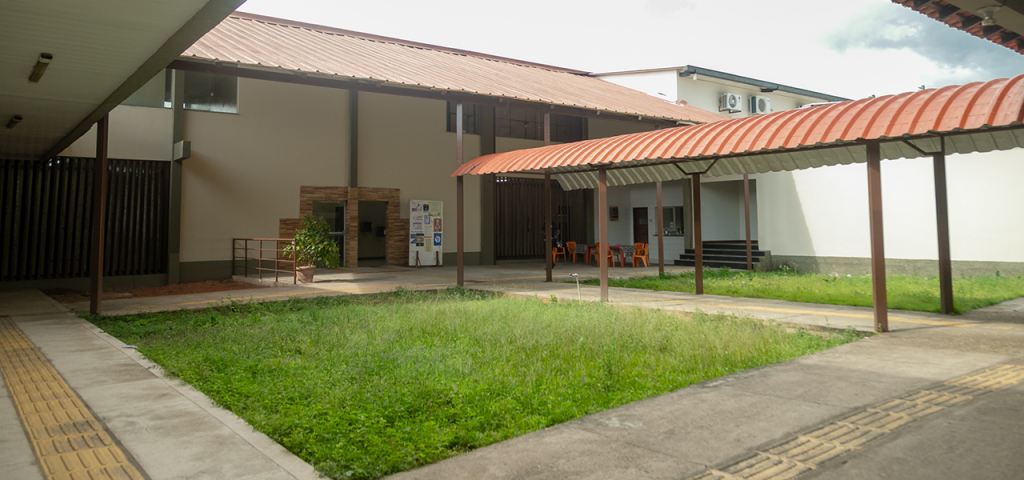 Fotografia da área interna do Instituto de Educação Matemática e Científica da UFPA. No centro, há uma área aberta com um jardim gramado.
