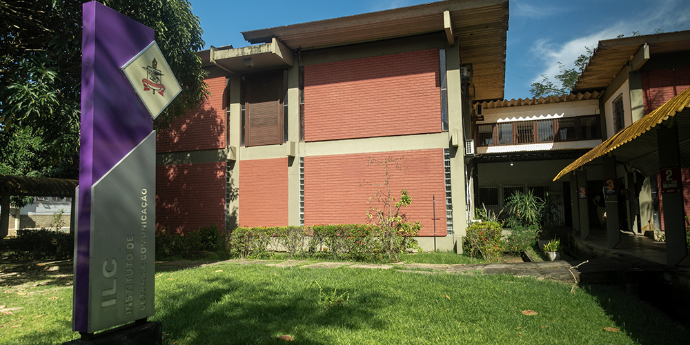 Fotografia da fachada do Instituto de Letras e Comunicação da UFPA. Em frente, há um totem de identificação do prédio.