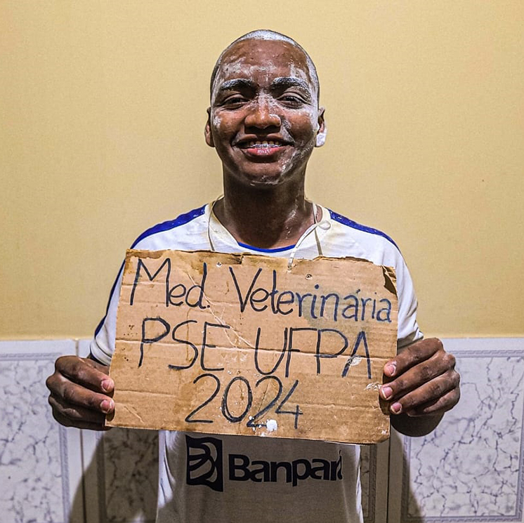 Foto do estudante quilombola Josias Junior, ele segura uma placa de papel com a escrita “Med. Veterinária UFPA. PSE 2024.