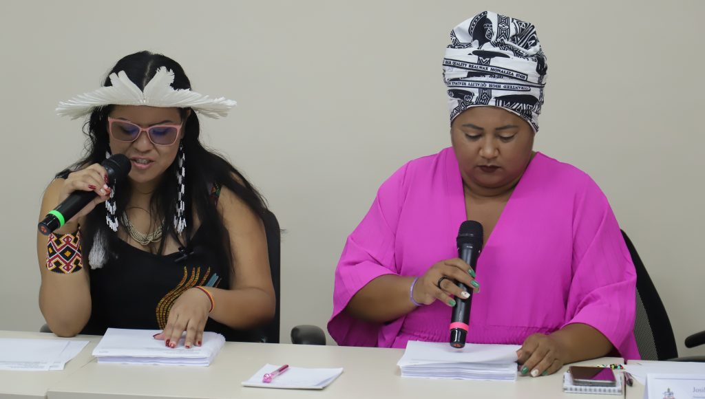 Fotografia registra as representantes da Associação dos Povos Indígenas Estudantes (APYEUFPA), Josilene Nunes; e da Associação dos Discentes Quilombolas (ADQ); Vanuza Cardoso, enquanto elas leem o listão dos aprovados no PSE Indígenas e Quilombolas 2024.