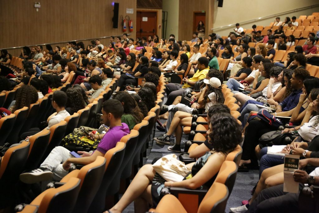 Fotografia mostra plateia de estudantes no auditório Benedito Nunes. 