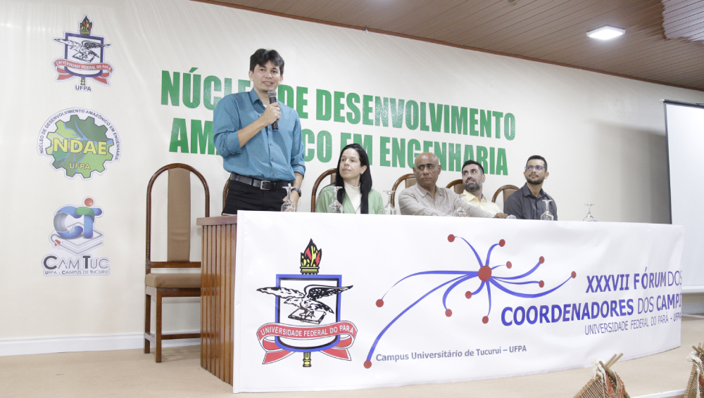 Fotografia da mesa do XXXVII Fórum dos Coordenadores dos Campi da UFPA. Na mesa estão o vice-reitor da UFPA, Gilmar Pereira; o coordenador do Campus Tucuruí, Wassin Banna; e outros três integrantes da gestão.