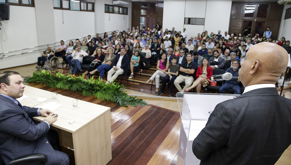 Fotografia de um auditório lotado. No canto inferior direito, é possível ver or eitor da UFPA de costa falando olhando para a plateia do auditório.