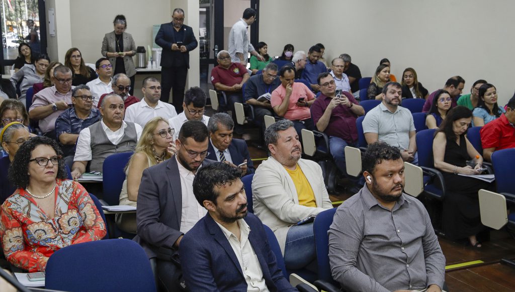 Fotografia da plateia de um auditório lotado.