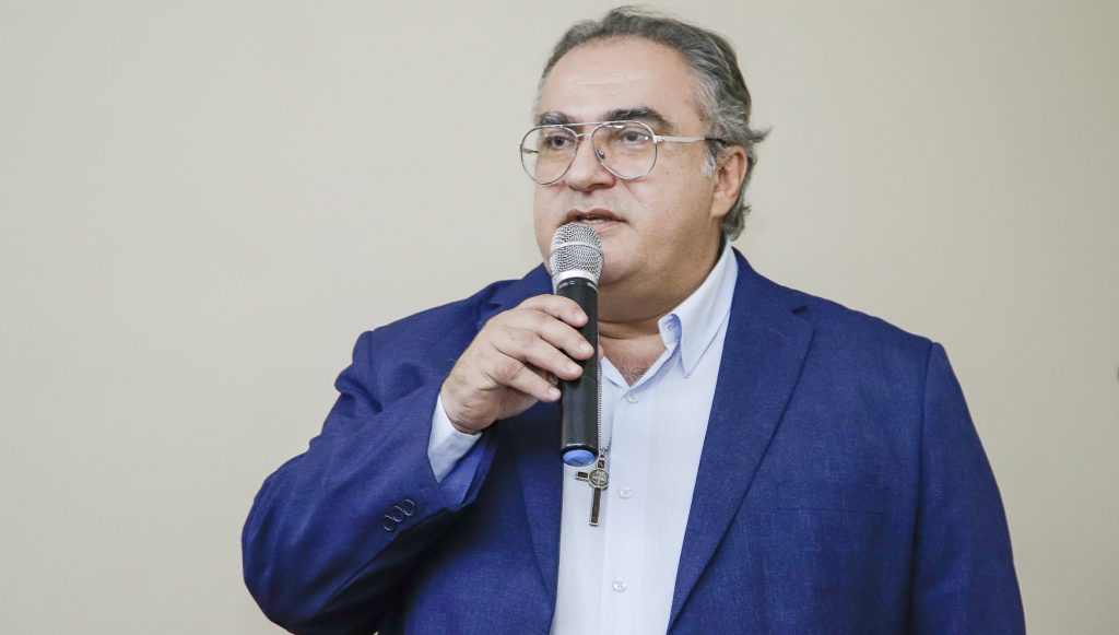 Fotografia do professor Davi Brasil falando ao microfone.