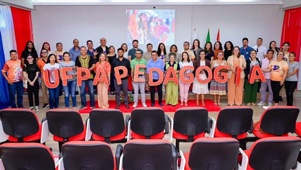 fOTOGRAFIA POSADA DE UM GRUPO GRANDE DE PESSOAS. oS QUE ESTÃO DISPOSTO NA PRIMEIRA FILA SEGURAM LETRAS QUE FORMAM O SEGUINTE TEXTO: UFPA PEDAGOGIA