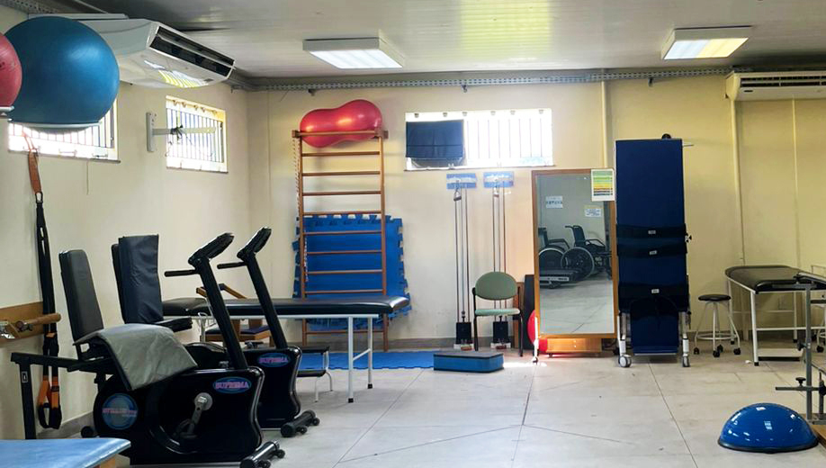 Fotografia de parte da sala de fisioterapia. Ela registra alguns aparelhos utilizados nas sessões.