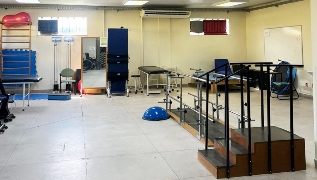 Fotografia de parte da sala de fisioterapia. Ela registra alguns aparelhos utilizados nas sessões.