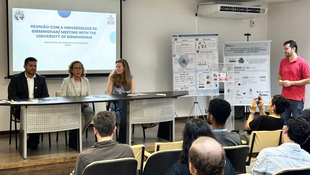 Fotografia registra a mesa do evento durante a fala da professora Lucilena Gonzaga, pró-reitora de Ensino de Graduação da UFPA.