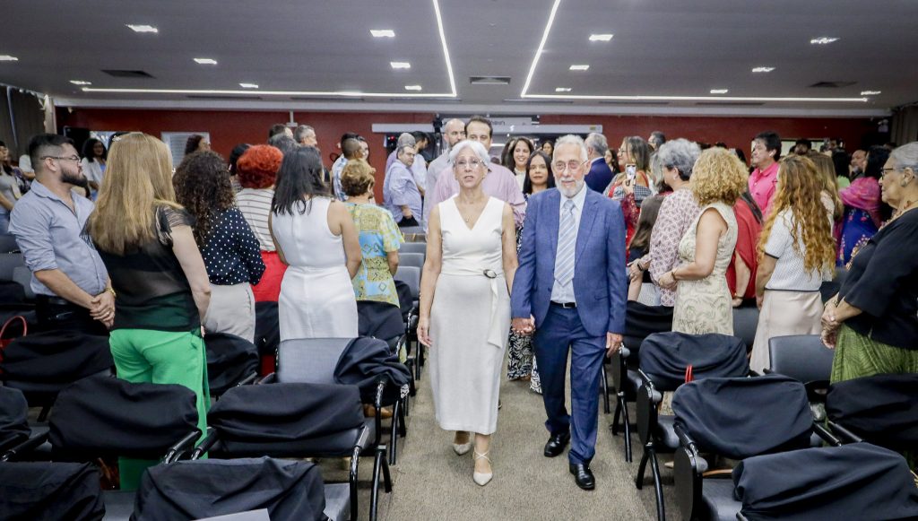 Fotografia de parte do cortejo realizado durante a cerimônia. Em destaque, na frente do cortejo, a professora Terezinha Valim Oliver Gonçalves e o professor Tadeu Oliver Gonçalves.