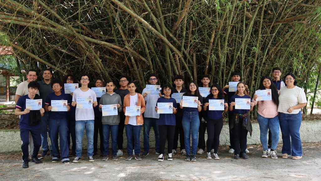 Foto posada de um grupo de estudantes da Escola de Aplicação da UFPA. Os jovens seguram diplomas.