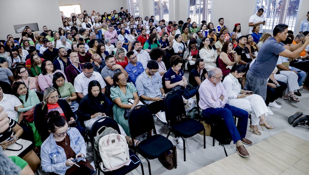 Fotografia registra um auditório lotado, com pessoas ocupando todas as cadeiras e algumas, ao fundo, em pé.