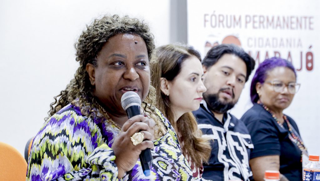 Fotografia close da ministra dos Direitos Humanos e da cidadania, Macaé Evaristo, falando ao microfone.