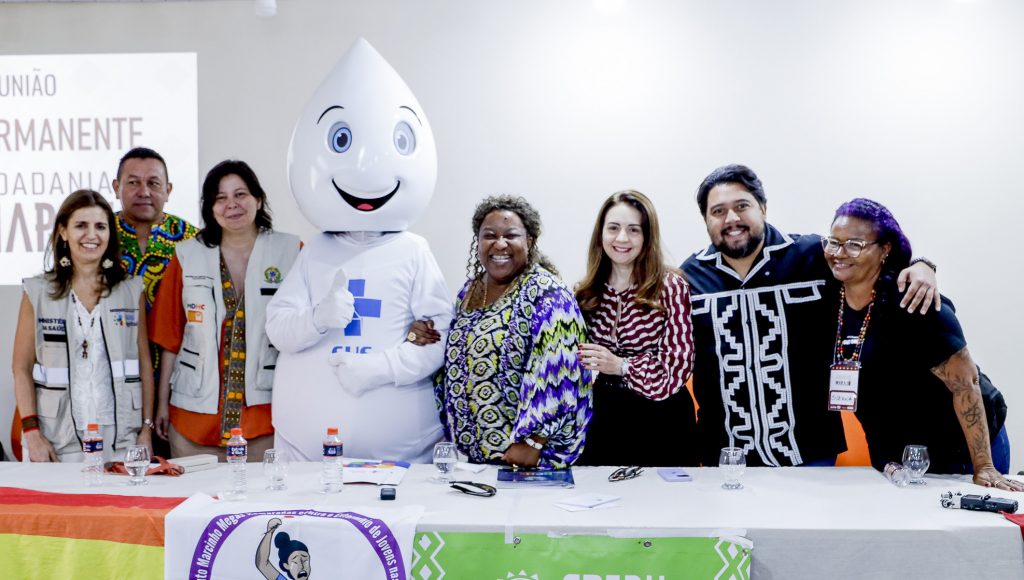 Fotografia posada registra um grupo de pessoas, entre eles estão o Zé Gotinha, mascote do Ministério da Saúde, a Ministra dos Direitos Humanos e da Cidadania, Macaé Evaristo, e a vice-reitora da UFPA, Loiane Prado Verbicaro.