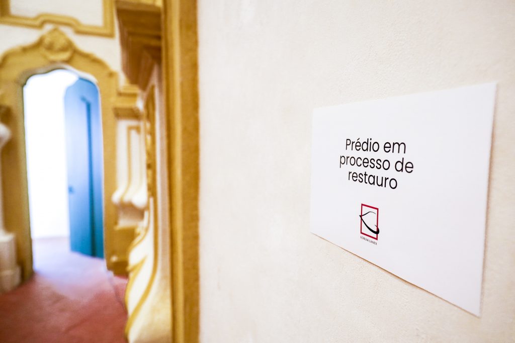 Fotografia destaca placa na parede com a inscrição "prédio em processo de restauro"