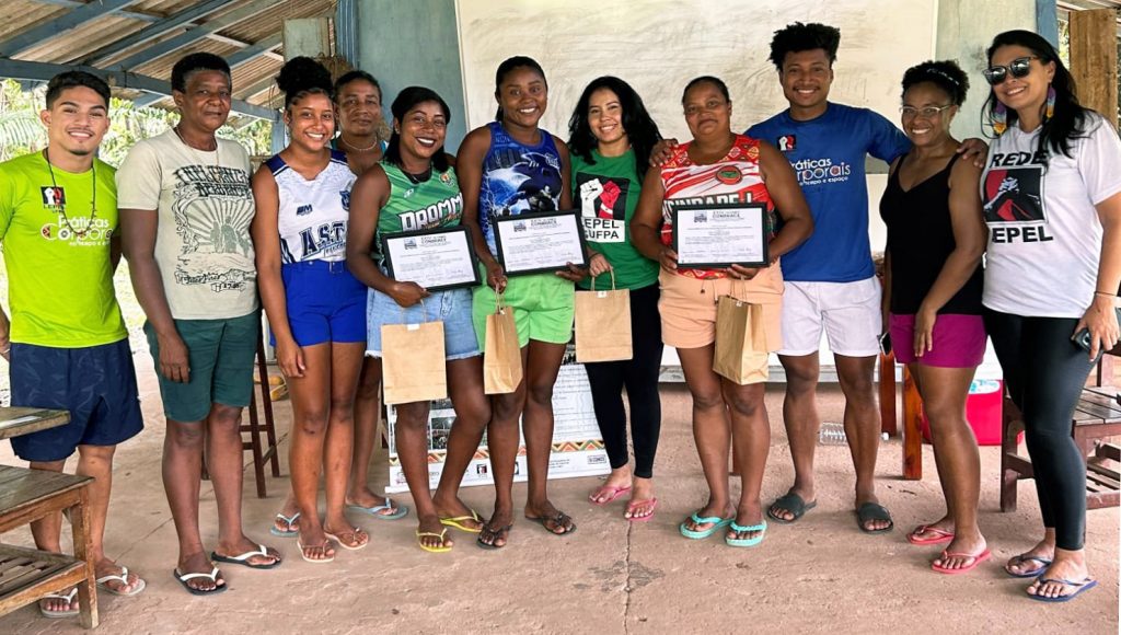 Foto ´posada de um grupo de jovens. Três dessas pessoas seguram certificados.