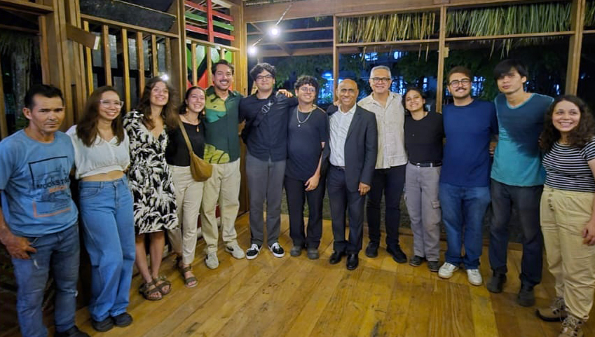Fotografia posada de um grupo de pessoas dentro do protótipo de casa.