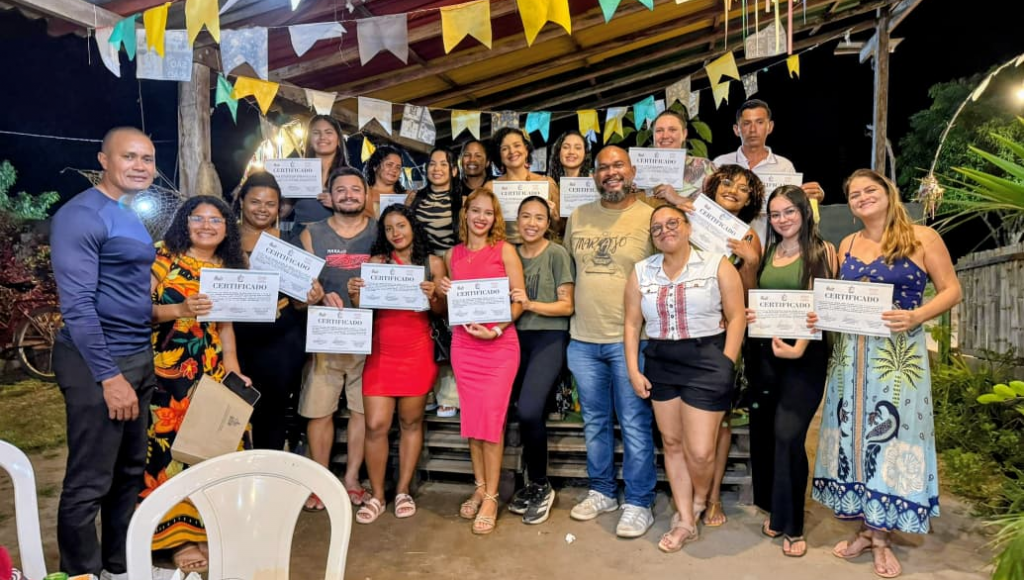 Fotografia posada de um grupo de pessoas. Algumas pessoas segurando certificados.