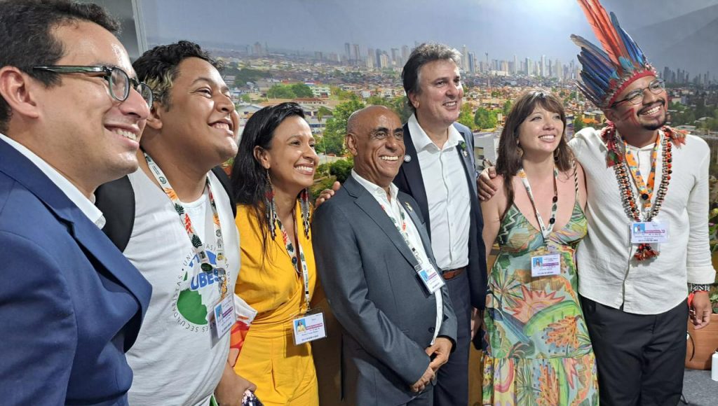 Fotografia posada de um grupo de pessoas. Todos sorriem.