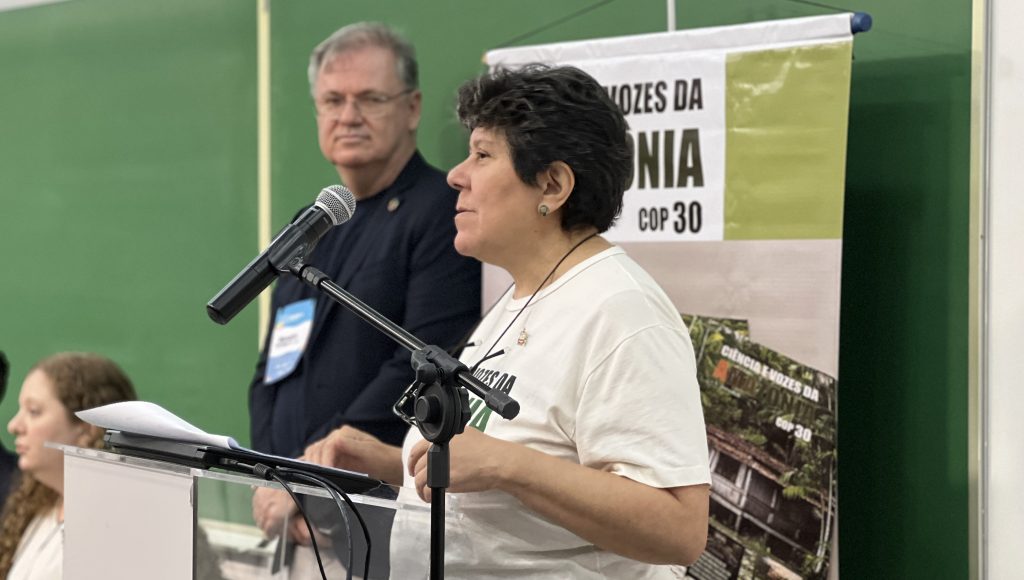 Fotografia da professora Athaíde Malcher falando ao microfone.