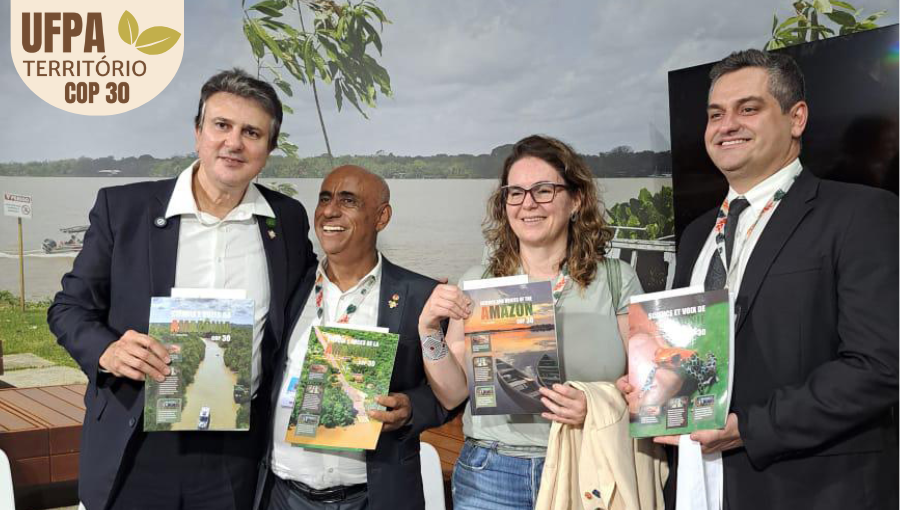 Fotografia posada registra quatro pessoas sorridentes, segurando revistas. Entre as pessoas estão o reitor da UFPA, Gilmar Pereira da Silva; e o Ministro da Educação, Camilo Santana. Sobre a foto, um selo identifica: UFPA TERRITÓRIO DA COP.