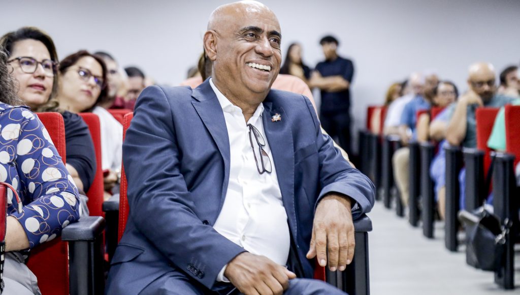 Fotografia registra o reitor da UFPA, Gilmar Pereira da Silva, sentado e sorrindo.