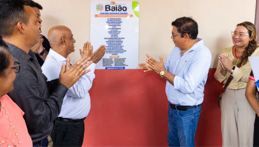 Fotografia mostra o reitor da UFPA e prefeito de Baião descerrando uma placa de inauguração. Outros dirigentes participam da foto. Todos aplaudem.