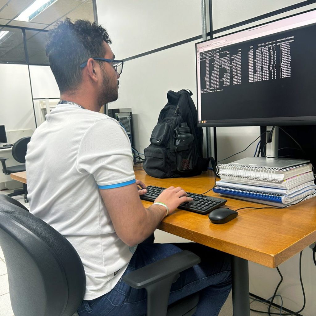 Fotografia registra um homem digitando em um teclado de computador.