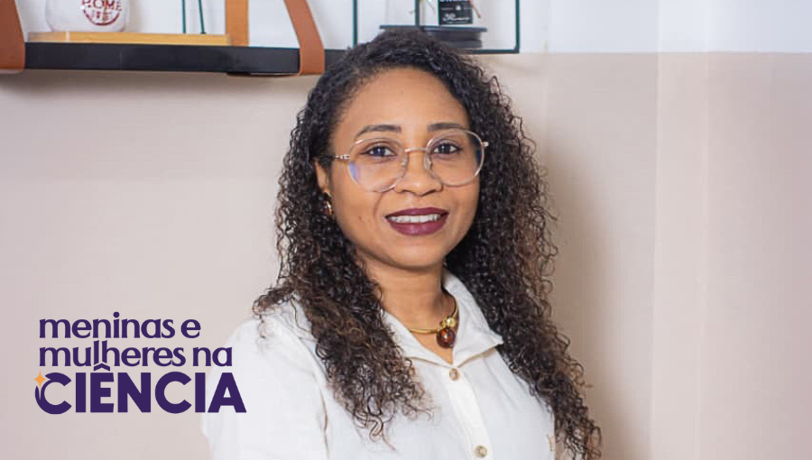 Fotografia posada de Ladyana dos Santos Lobato. Ela é uma mulher negra, de cabelos cacheados na altura do ombro. Usa óculos de grau de armação redonda e uma blusa branca de manga. Sobre a foto há uma logomarca: MENINAS E MULHERES NA CIÊNCIA.