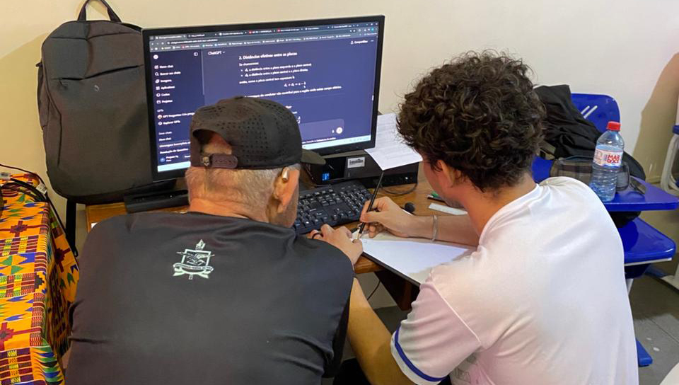 Fotografia registra duas pessoas de frente para um computador. Uma das pessoas veste uma camisa com o brasão da UFPA.