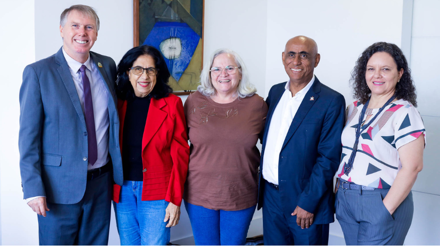 Fotografia mostra grupo de pessoas sorrindo. Entre as pessoas estão o reitor da UFPA, homem negro e calvo e o reitor da UFNT, homem branco e grisalho.