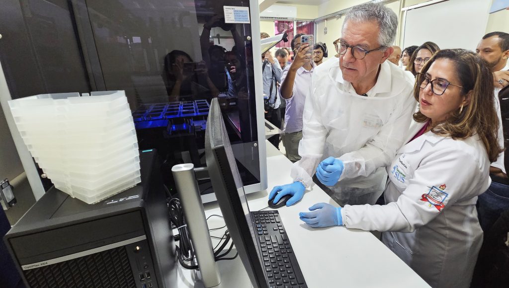 Fotografia registra o ministro de Saúde, Alexandre Padilha, e a professora da UFPA Ândrea Ribeiro dos Santos, coordenadora do Genoma SUS na UFPA, manipulando um mouse olhando para a tela de um computador.