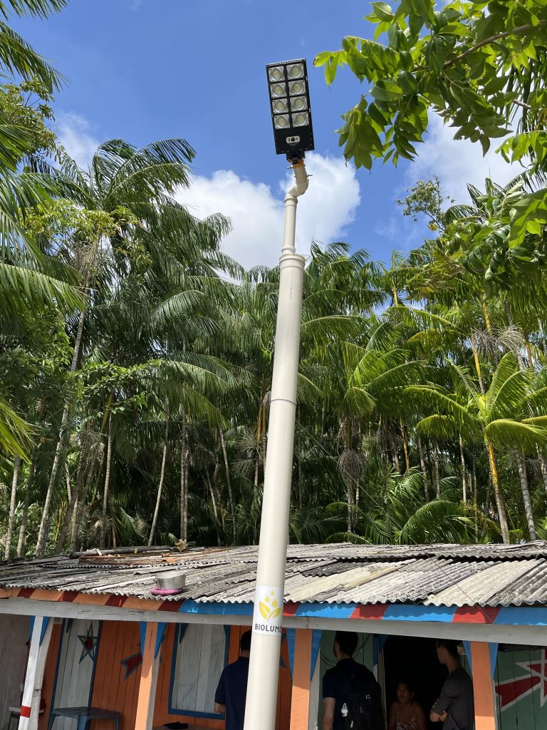 Fotografia destaca um posto em frente a uma casa de madeira.