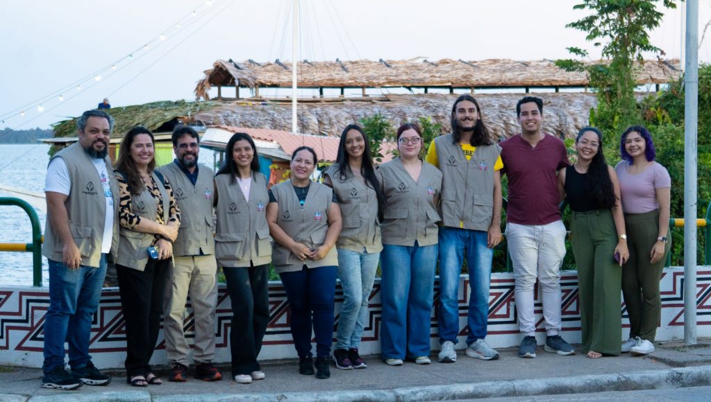 Fotografia posada de um grupo de pessoas. A maioria do grupo usa coleta com o brasão da UFPA bordado.