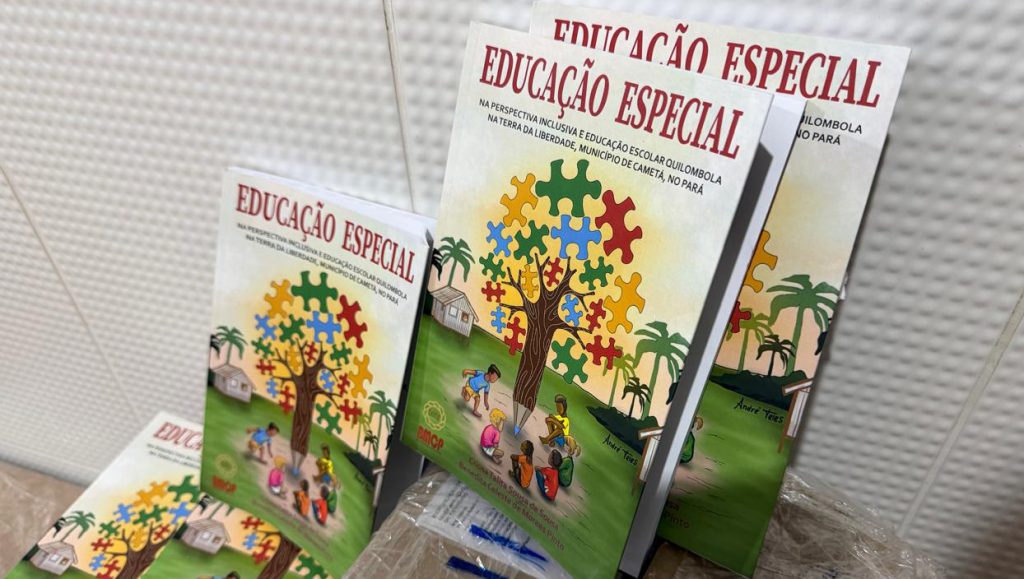 Fotografia registra três exemplares de um livro. Na capa do livro há p desenho de uma árvore com folhas em formato de peças de quebra-cabeça. Sobre a árvore, o título do livro: ducação especial na perspectiva inclusiva e educação escolar quilombola na Terra da Liberdade, Município de Cametá, no Pará.