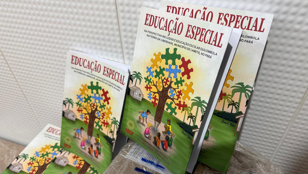 Fotografia registra três exemplares de um livro. Na capa do livro há p desenho de uma árvore com folhas em formato de peças de quebra-cabeça. Sobre a árvore, o título do livro: ducação especial na perspectiva inclusiva e educação escolar quilombola na Terra da Liberdade, Município de Cametá, no Pará.