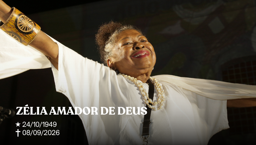 Fotografia da professora Zélia Amador de Deus, toda vestida de branco, sorrindo de braços abertos. Sobre a imagem, o seginte texto: ZÉLIA AMADOR DE DEUS - 24/10/1949 - 08/09/2026.
