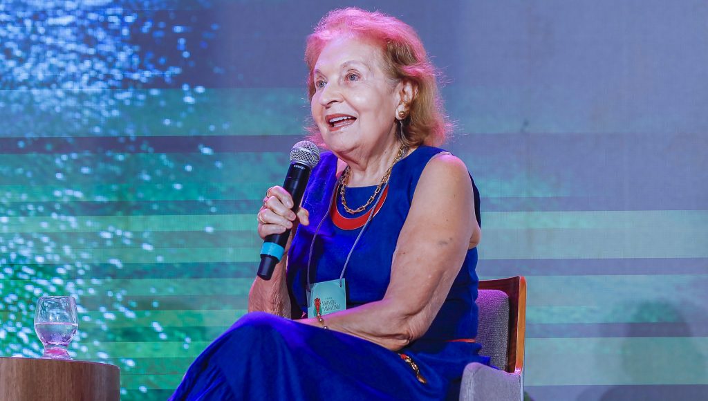 Fotografia registra a professora da UFPA Violeta Loureiro, falando ao microfone.